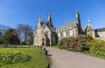 Vista frontal de Lauriston Castle con jardines floridos y sendero