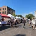 Vista general del German Village Makers Market con puestos bajo carpas y visitantes caminando