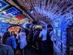 Interior del club con techo abovedado de ladrillo, iluminación azul y público disfrutando del ambiente