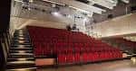 Interior del auditorio con butacas rojas y escenario