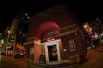 Fachada nocturna del edificio The Lanes con iluminación cálida y arco característico