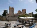 Plaza exterior del convento con mesas y sombrillas, ideal para eventos al aire libre