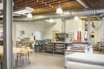 Taller de impresión con maquinaria industrial y espacio abierto para eventos
