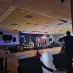 Interior del club con escenario iluminado y barra de bebidas