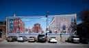 Vista de un mural histórico en East Passyunk Avenue con edificios y coches estacionados