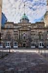 Vista exterior del Trades Hall de Glasgow con fachada neoclásica y cúpula verde