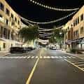 Perspectiva central de la calle High Street por la noche con decoración lumínica y tráfico ligero