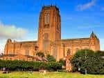 Vista exterior de la Catedral de Liverpool bajo un cielo azul con nubes