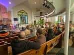 Interior de la iglesia durante un evento con asistentes sentados