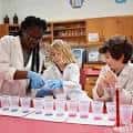 Educador guiando a estudiantes en una actividad de laboratorio