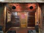 Escenario exterior con techo de chapa y paredes de madera