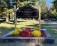 Señal de entrada al Mount Moriah Cemetery & Arboretum rodeada de flores