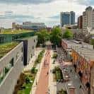 Paseo peatonal entre edificios modernos del campus con techos verdes