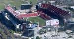 Aterrizaje panorámico del estadio con el campo de juego visible y gradas rojas