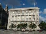 Vista frontal del Cunard Building en Liverpool con banderas y cielo azul