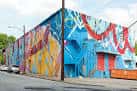 Vista exterior del Westside Cultural Arts Center con fachada de murales coloridos