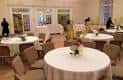 Sala de eventos decorada con mesas redondas y sillas para una celebración