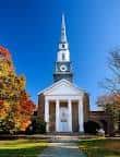 Vista exterior de la Iglesia Presbiteriana de Chestnut Hill con su torre y campanario bajo un cielo azul
