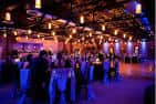 Interior del salón de eventos Edison's en Dallas con iluminación cálida y mesas decoradas para una celebración