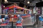 Interior del Tin Roof con barra central y mesas para eventos