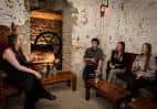 Grupo de personas conversando en un ambiente acogedor con chimenea