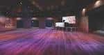 Interior del espacio de eventos con escenario y luces ambientales