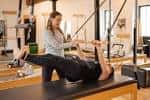 Sesión de Pilates reformer con instructora y cliente en el interior del estudio