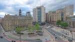 Vista panorámica del City Square de Leeds con edificios históricos y modernos bajo cielo nublado