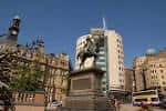 Plaza central del City Square con estatua ecuestre y arquitectura urbana al atardecer