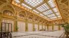 Salón de eventos decorado con columnas doradas y luz natural