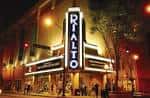 Fachada nocturna del Rialto Center for the Arts con letrero iluminado y ambiente urbano