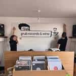 Personal instalando el logo de Grub Records & Wine en la pared