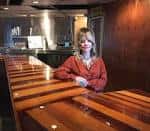 Interior del bar con una persona sentada en la barra de madera
