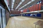 Sala principal del Kings Heath Community Centre con suelo de madera y paredes rojas