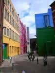 Vista de la calle principal del Custard Factory con edificios de colores vibrantes