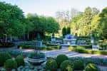 Vista panorámica del jardín con estanque central y vegetación exuberante