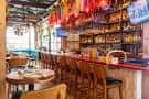 Interior del bar con barra de madera y decoración colorida