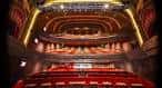 Interior del auditorio con butacas rojas y escenario