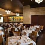 Salón principal del restaurante preparado para eventos con iluminación cálida
