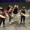 Grupo de personas jugando con equipos de realidad virtual en Sandbox VR