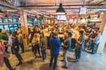 Interior del Philadelphia Brewing Company con ambiente festivo y personas disfrutando