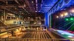 Interior amplio del venue con gradas y escenario iluminado