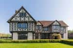 Fachada principal de Blakesley Hall mostrando detalles arquitectónicos históricos bajo cielo despejado