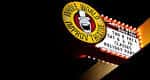 Letrero iluminado de Whole World Improv Theatre en la noche