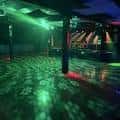 Interior del venue con luces verdes y ambiente de fiesta