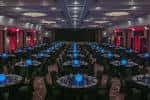 Sala de eventos del National Conference Centre con mesas redondas y decoración en tonos rojos