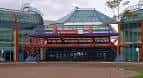 Entrada frontal del NEC Birmingham con detalles arquitectónicos en rojo y vidrio