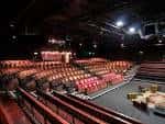 Interior del auditorio con butacas rojas y escenario