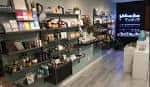 Interior del Bliss Wellness Market con estanterías de productos y pantalla digital