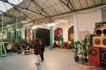 Interior del espacio con decoración artística y personas caminando, ambiente cultural